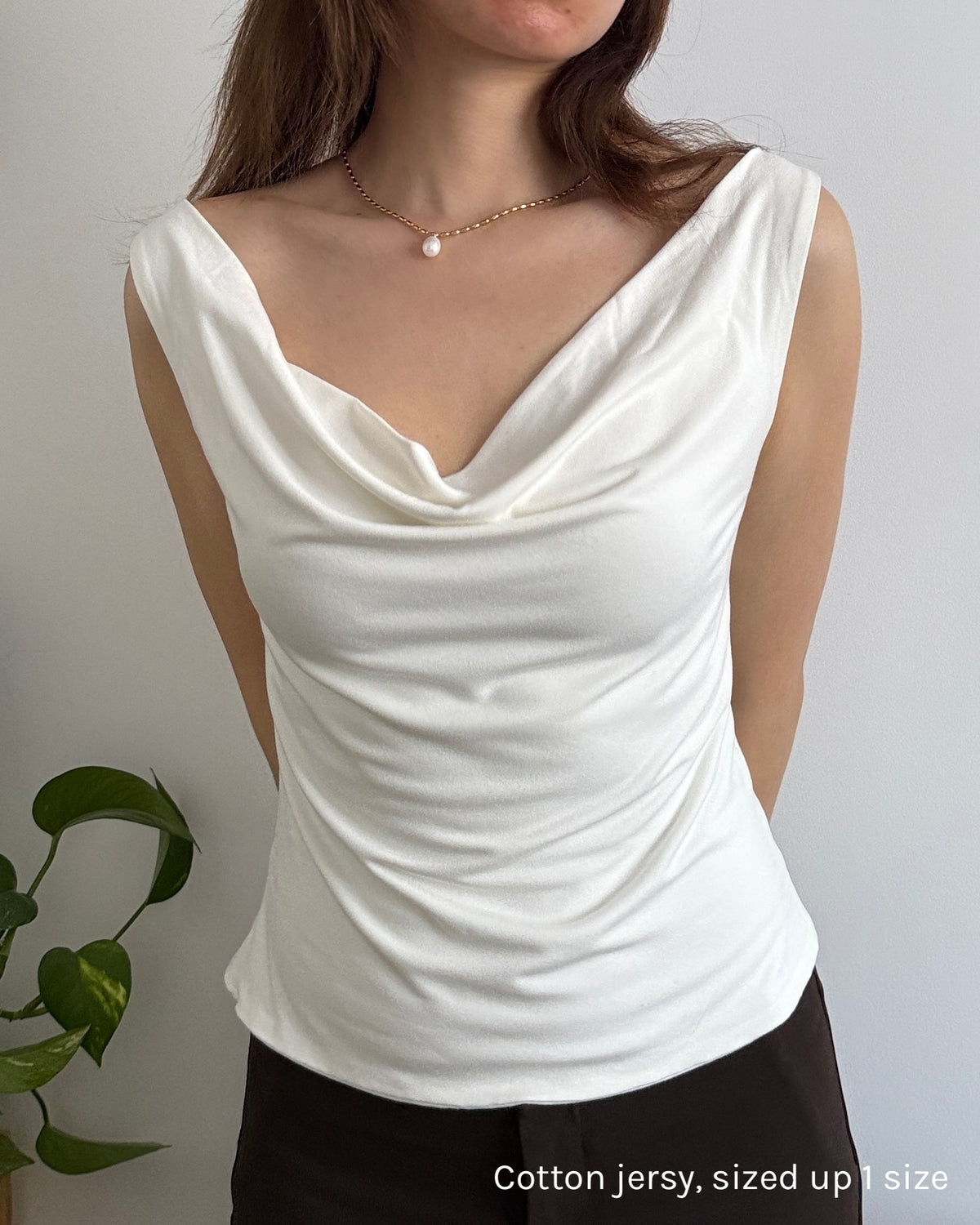 Cotton jersey top with cowl neck worn by a woman against a plain background